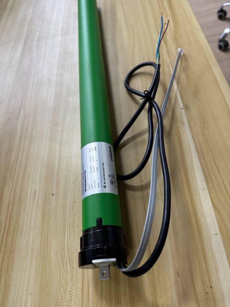 Grüner DOOYA-Rohrmotor mit Anschlusskabeln für das ZIP-Screen-Rollo am Lamellendach