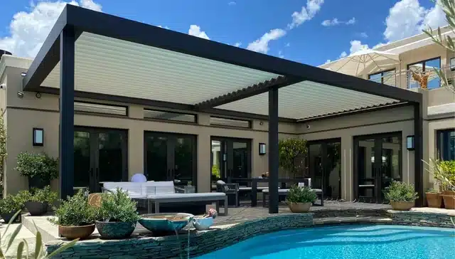 Großes Lamellendach mit schwarzem Rahmen über Lounge und Essplatz am Pool