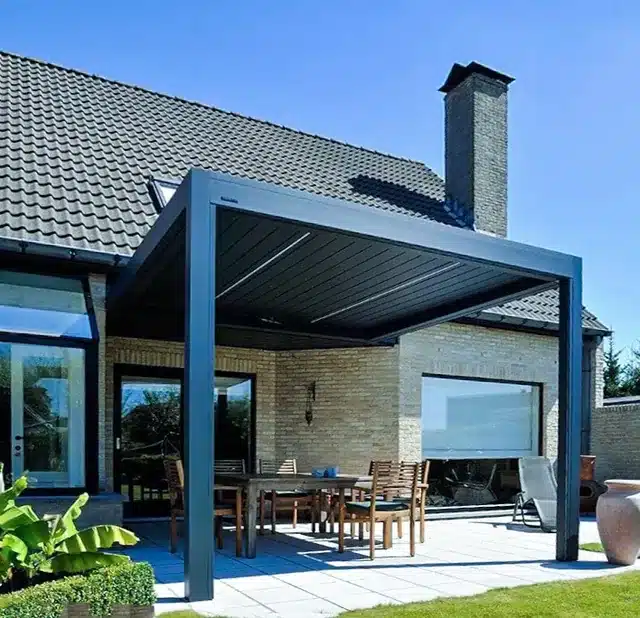 Pergola mit Lamellendach in Anthrazit an Klinkerhaus über gedecktem Essplatz auf der Terrasse