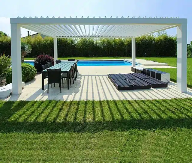 Weißes Lamellendach über Terrasse mit Esstisch, Pool und gepflegtem Garten