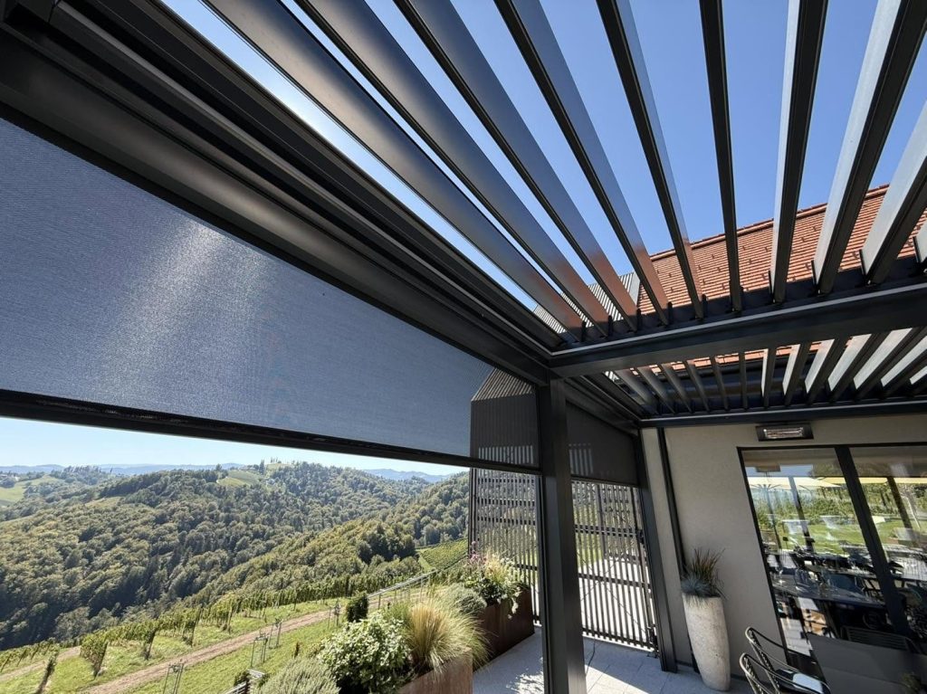 Blick unter ein Lamellendach in der Südsteiermark mit Seitenscreen auf die Weinberge der Südsteiermark