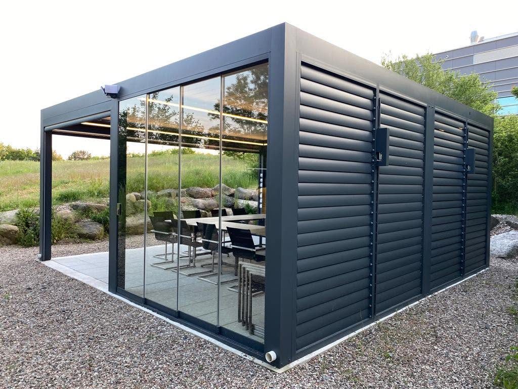Pergola in Frankfurt (Oder) mit Glasschiebewand und Lamellenwand an der Seite, darunter ein Besprechungstisch