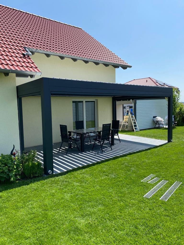 Anthrazitfarbene Pergola in Großhabersdorf am Haus mit Ziegeldach, auf der Terrasse steht ein Esstisch