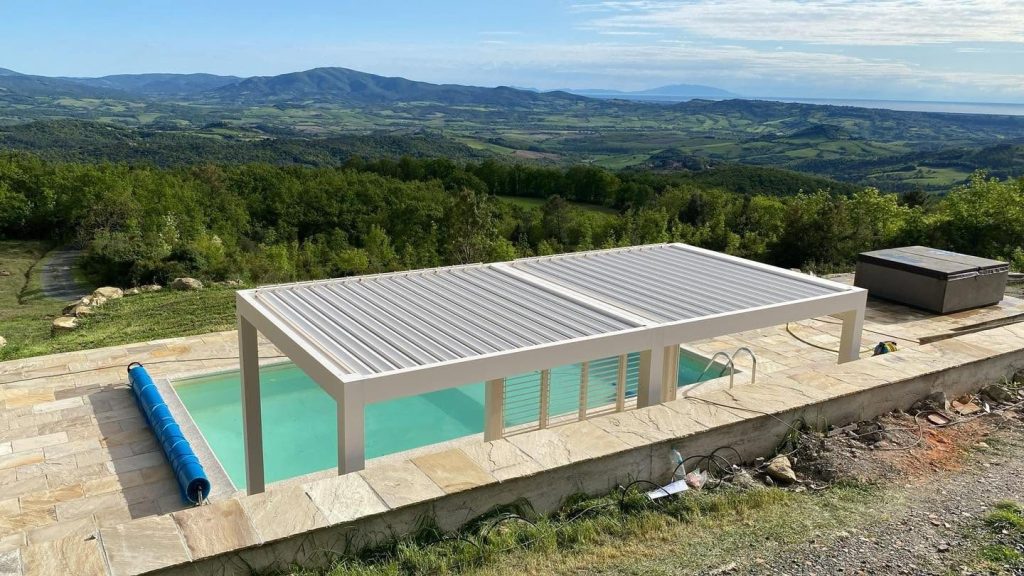 Pool mit weißem Lamellendach in der Toskana, dahinter eine weite Hügel- und Waldlandschaft