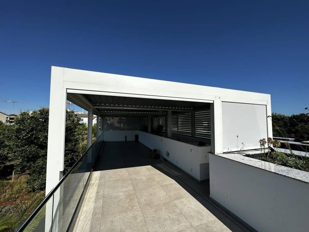 Weißes Lamellendach auf einer Dachterrasse mit Hochbeeten und Glasgeländer