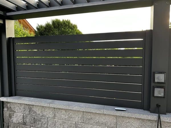 Lamellenwand auf der Natursteinmauer – Outdoor-Küche deluxe
